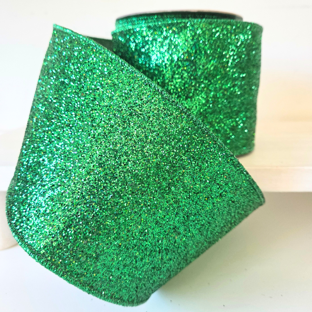 High quality USA imported wired ribbon. 4" wide ribbon in emerald green, made with shimmering laser glitter.. Sold by the meter