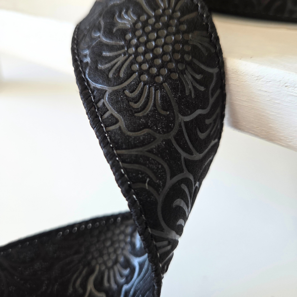 USA imported wired ribbon, 1.5" wide, in black with an embossed flower design. Sold by the meter.