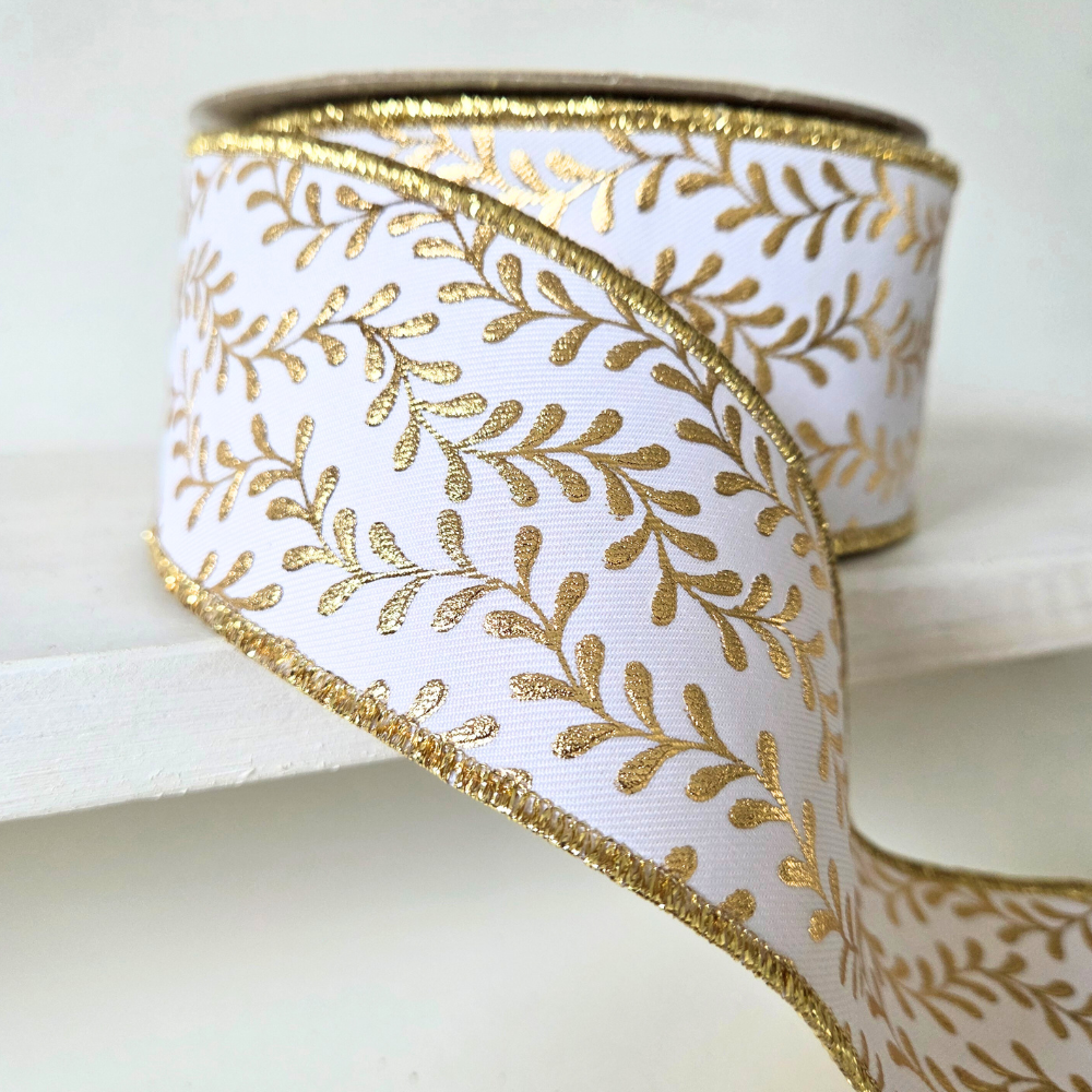 High quality premium USA imported wired ribbon.  This ribbon is a deluxe 2.5" wide fused ribbon, in white with gold leaf pattern.  Sold by the meter