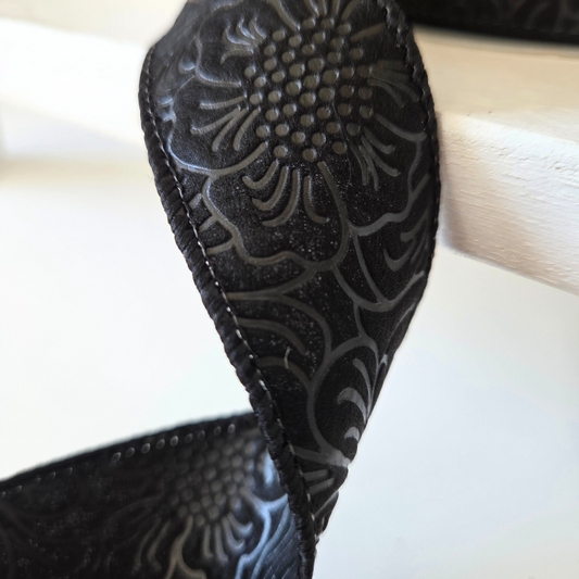 USA imported wired ribbon, 1.5" wide, in black with an embossed flower design. Sold by the meter.