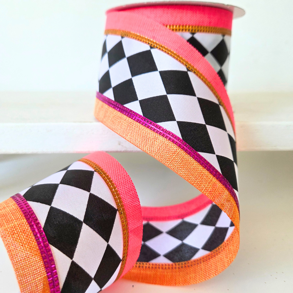 USA imported wired ribbon, 2.5" wide, with a Harlequin Satin Linen Edge design in Black, White, Orange, and Hot Pink.  Sold by the meter.